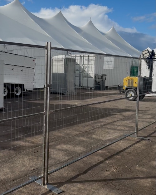 Tribute Fencing & Barricade 6 ft welded wire temporary fence panel on a steel stand, set up outside event tents